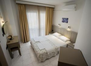 a bedroom with a bed and a desk and a window at Hotel Turunç-Malmen in Turunc
