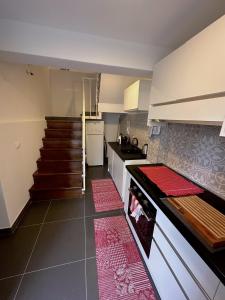 una cocina con azulejos rojos en el suelo y escaleras en Butterfly House, en La Spezia