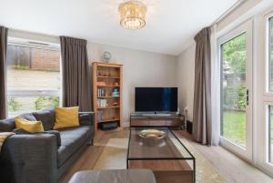 sala de estar con sofá y TV en Modern 3BR Flat quick links to LDN & Heathrow, en Shepperton