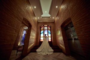 Hotel Otavalo في اوتابالو: عروس تقف في غرفة مع نافذة
