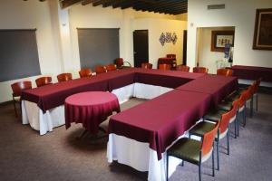 une grande salle de réunion avec des tables et des chaises pourpres dans l'établissement Hotel Posada El Rey Sol, à Ensenada