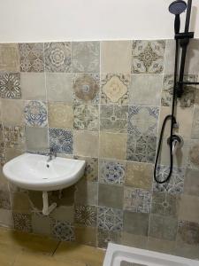 een badkamer met een wastafel en tegels op de muur bij Home Rebecca in Napels