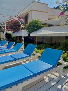 een rij blauwe ligstoelen op een patio bij Hosteria Suiza in Ica