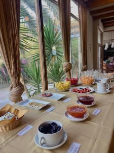 stół z talerzami żywności, kubkami i miskami żywności w obiekcie Hosteria Suiza w mieście Ica