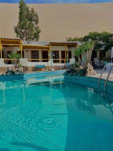 a large swimming pool in front of a house at Hosteria Suiza in Ica