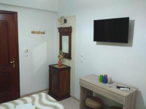 salon z telewizorem na ścianie w obiekcie CASA KIRKI w mieście Ágios Rókkos