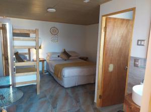 1 dormitorio con 1 cama y 1 litera en Casa Ñawi, en San Pedro de Atacama