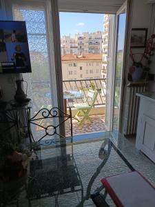 une pièce avec une table en verre et une vue sur un balcon dans l'établissement 2 pieces proche aéroport, à Nice 2 autres photos