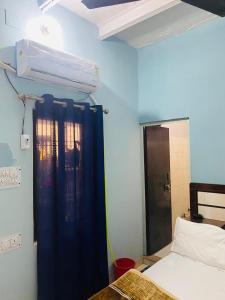 a room with a bed and a blue wall at Ram Paying Guest House & Hostel Near by Krishna Janmabhoomi GROUP OF MANAVI in Mathura