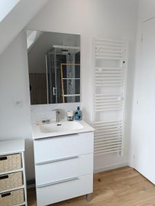 Baño blanco con lavabo y espejo en Elégant Studio ~Hyper Centre~, en Coutances
