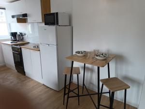 cocina con mesa pequeña y nevera blanca en Elégant Studio ~Hyper Centre~, en Coutances