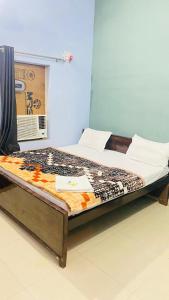 a bed sitting in a room with avertisementatronatronstrationstrationstration at Ram Paying Guest House & Hostel Near by Krishna Janmabhoomi GROUP OF MANAVI in Mathura