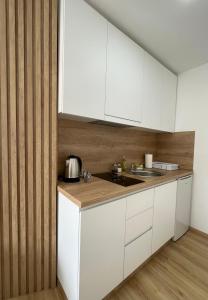 a kitchen with white cabinets and a sink at Apartmani Videnovic Sokobanja in Soko Banja