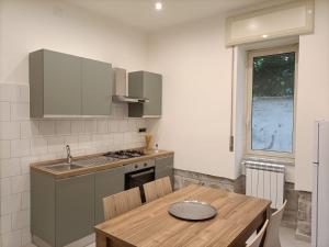 a kitchen with a wooden table and a sink at ALTAMAREA appartamenti sul porto in Pozzuoli