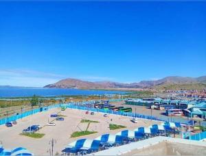 ein Strand mit blauen Sonnenschirmen und dem Wasser in der Unterkunft INKA'S DREAMS HOUSE in Puno