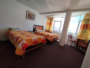 a bedroom with two beds and a window at INKA'S DREAMS HOUSE in Puno