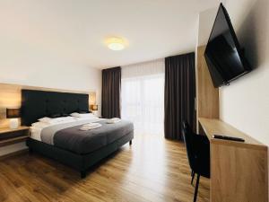 ein Hotelzimmer mit einem Bett und einem Flachbild-TV in der Unterkunft ROYAL VILLA - Adults Only - Pokoje z widokiem na Zalew Wiślany-Grupa PlażoweLove in Krynica Morska