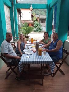 een groep mensen die rond een tafel zitten bij Canto do mar in Paraty