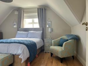 a bedroom with a bed and a chair and a window at Enniscrone Luxury Double Room in Enniscrone