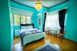 a blue bedroom with a bed and a table and chairs at Hotel Renk Palace in Buyukada