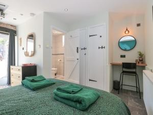 a bedroom with a bed with two green towels on it at The Boar in Blakeney