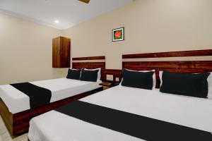 duas camas num quarto de hotel com duas em OYO Hotel Leela Elite em Vijayawada