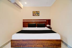 um quarto com uma cama grande e uma cabeceira em madeira em OYO Hotel Leela Elite em Vijayawada