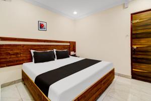um quarto com uma cama grande e uma cabeceira em madeira em OYO Hotel Leela Elite em Vijayawada