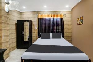 um quarto com uma cama e uma janela em OYO Flagship Hotel Shiva Inn em Jamshedpur