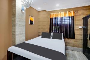 a bedroom with a bed and a window at OYO Flagship Hotel Shiva Inn in Jamshedpur