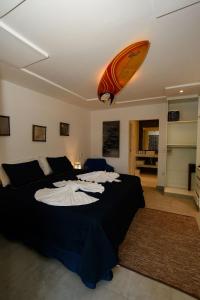 een slaapkamer met een bed met een surfplank aan het plafond bij Aqui Bate a Brisa Pousada in Arraial d'Ajuda