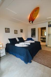 um quarto com uma cama com uma prancha de surf na parede em Aqui Bate a Brisa Pousada em Arraial d'Ajuda