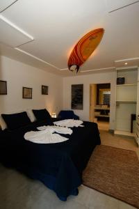 a bedroom with a bed with a surfboard on the ceiling at Aqui Bate a Brisa Pousada in Arraial d'Ajuda