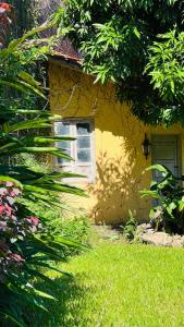 una casa amarilla con ventana y patio en Casona Margarita en Concordia