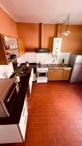 cocina con electrodomésticos blancos y suelo de baldosa roja en Casona Margarita en Concordia