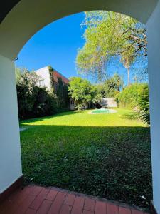 un arco que conduce a un patio con césped verde en Casona Margarita en Concordia