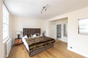 4 Bedroom Townhouse Seconds Away from Harrods في لندن: غرفة نوم بسرير كبير في غرفة
