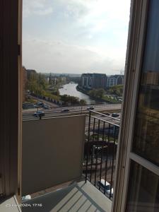 a balcony with a view of a river and freeway at Nad Motławą , Szopy 3 in Gdańsk