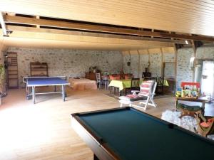 um quarto com uma mesa de bilhar e uma sala de estar em Gîte de France à Sarroux - St Julien 3 épis - Gîte de France 8 personnes 134 em Sarroux
