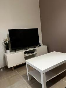 a living room with a flat screen tv on a white cabinet at Appartement des Carmes in Nîmes