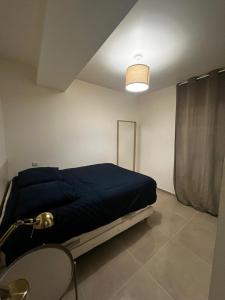 Un dormitorio con una cama con una manta azul. en Appartement des Carmes en Nimes