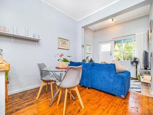sala de estar con sofá azul y mesa en Cosy Victorian Style Full Apartment, en Ciudad del Cabo