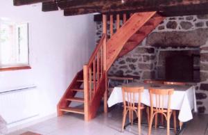 a staircase in a room with a table and chairs at Gîte de France Le fournil 3 épis - Gîte de France 2 personnes MAE-5564 in Égletons