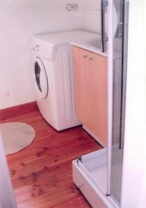 a washer and dryer in a room with a wooden floor at Gîte de France Le fournil 3 épis - Gîte de France 2 personnes MAE-5564 in Égletons +14 photos