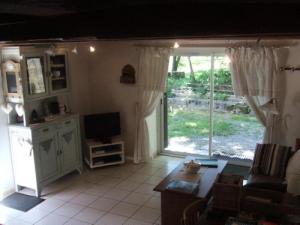 a living room with a large window and a television at Gîte de France Le fournil 3 épis - Gîte de France 2 personnes MAE-5564 in Égletons