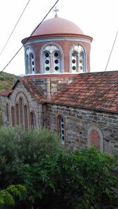 eine alte Kirche mit einem Turm darüber in der Unterkunft Zorbas Apartments in Volissos