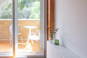 a kitchen with a sliding glass door with a table and chair at B&B Le foglie d'ulivo in Bari +30 photos