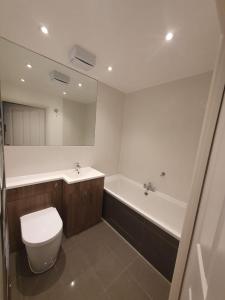 La salle de bains est pourvue de toilettes, d'un lavabo et d'une baignoire. dans l'établissement Broxbourne apartment (2 bed), à Broxbourne