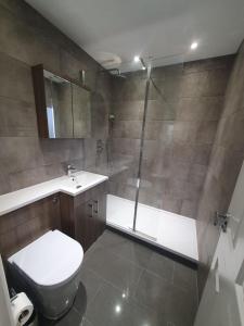 La salle de bains est pourvue d'une douche, de toilettes et d'un lavabo. dans l'établissement Broxbourne apartment (2 bed), à Broxbourne