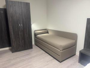 un sofá en una habitación con un armario de madera en Da Noi Trattoria Hotel, en Vergato